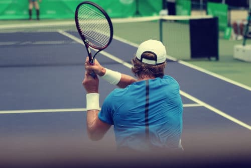Unfallversicherung - erhöhte Kraftanstrengung bei Rückhandschlag eines Tennisspielers